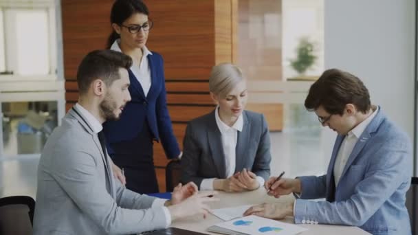 Young businessman in suit signing contract and shake hands with his colleague while corporate lawyer explaining details of partnership sitting in modern office — Stock Video