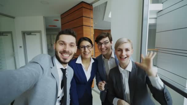 POV of Happy equipo de negocios que tiene chat de vídeo en línea utilizando la cámara del teléfono inteligente y hablar con su colega en la oficina moderna — Vídeos de Stock