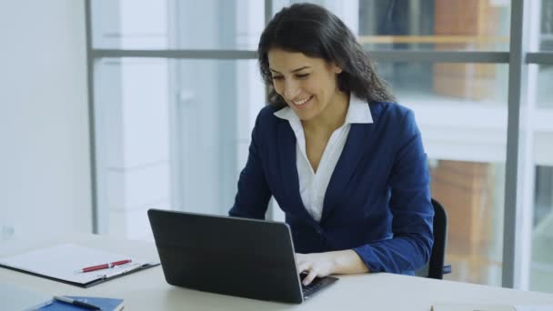 Młoda kobieta przy użyciu komputera przenośnego, dobry komunikat i stają się bardzo podekscytowany i szczęśliwy siedzi w nowoczesnym biurze — Wideo stockowe
