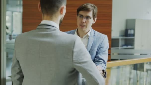 Dolly záběr ze dvou podnikatel kolegové stojící a chatování, stojící vedle zábradlí v hale moderní business centrum — Stock video