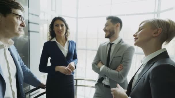 Empresárias e colegas de negócios conversando no elevador em movimento e sair dele no moderno centro de negócios — Vídeo de Stock