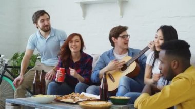 Paylaşılan daire ve birlikte şarkı evde gitar çalmak onların arkadaşı parti mutlu genç arkadaşlar var