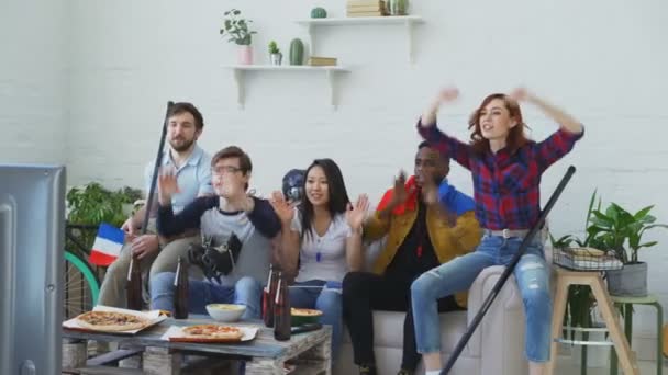 Skupina mladých přátel sportovní fanoušky s francouzskou státní vlajky sleduje sportovní mistrovství v televizi společně a radost z vítězství doma oblíbený tým — Stock video