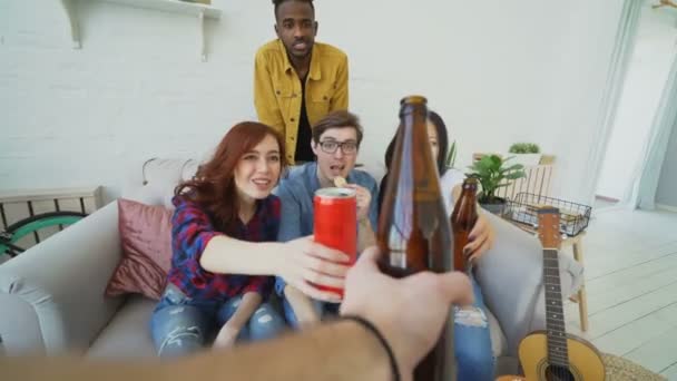 POV colpo di mano maschile tintinnante bottiglia di birra con gli amici mentre si celebra festa a casa al chiuso — Video Stock