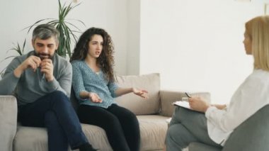 Öfkeli kadın savunarak ve evlilik danışmanı kocasına konuşuyor. Profesyonel psikolog office ziyaret genç Çift