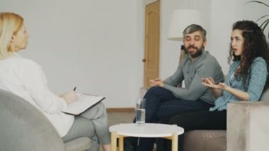 Öfkeli kadın savunarak ve evlilik danışmanı kocasına konuşuyor. Profesyonel psikolog office ziyaret genç Çift