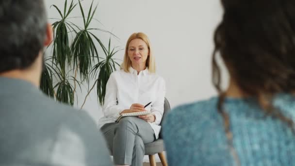 Psychanalyste expérimentée féminine parlant avec un couple marié essayant de résoudre leurs difficultés relationnelles — Video