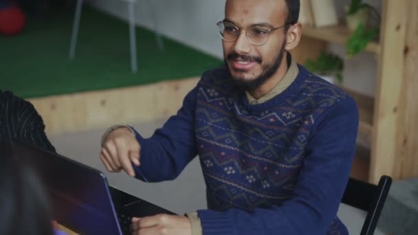 Joyeux homme afro-américain dans des lunettes souriant tout en discutant du nouveau projet de start-up avec l'équipe au bureau — Video