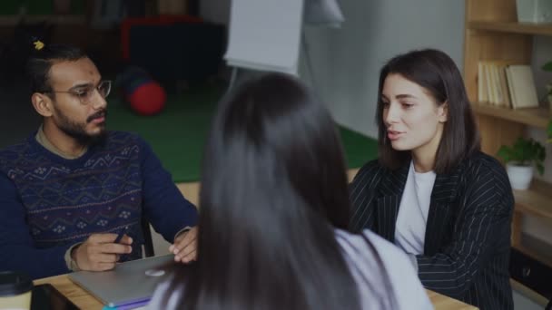 Groupe de jeunes gens d'affaires multi-ethniques assis sur le bureau avec des ordinateurs portables travaillant et parlant de nouveau projet de démarrage dans le bureau loft moderne — Video