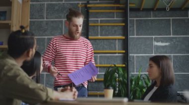 Başlangıç blockchain proje çok etnik takım gösteren kağıt planı ile tartışırken genç hippi erkek lideri