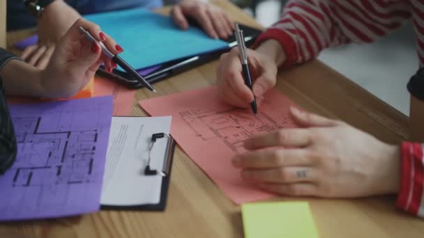 Fechamento da mão masculina apontando para o plano de papel arquitetônico discutindo projeto com colegas durante brainstorming de projetos de start-up no escritório da agência criativa — Vídeo de Stock