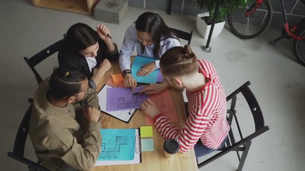 Bovenaanzicht van start-up bedrijf multi-etnische team bespreken nieuw project in moderne loft kantoor — Stockvideo