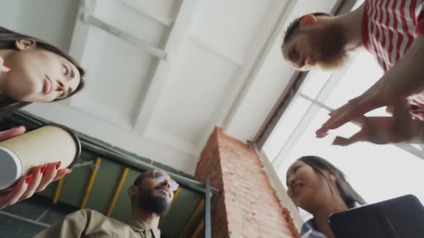 Low-Winkelansicht von Start-up-Business-Team von multiethnischen Menschen zusammengestellt Palmen nach erfolgreicher Einigung über neues Projekt in modernen Loft-Büro — Stockvideo