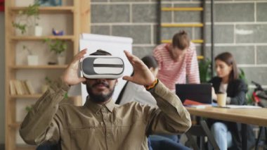 Afrika kökenli Amerikalı adam VR simulator oyun geliştirme ofisinde test. Gelecekte sanal gerçeklik teknolojisi projesi tartışmaya başlamak-yukarıya yaratıcı ekibi