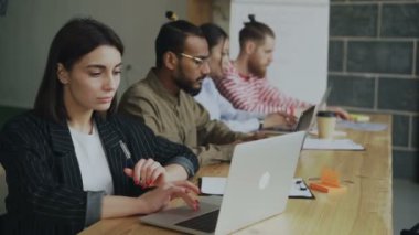 Çalışma ve meşgul coworking ofiste dizüstü bilgisayar kullanan genç kadın girişimci serbest meslek. İş kadını ve teknoloji proje üzerinde konsantre takım