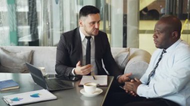 Tahriş olmuş bussinessman öfkeyle onun Afro-Amerikan çalışan modern Café gömlekli azar takım elbiseli. Kızgın CEO'su eliyle tablo endişeyle grev