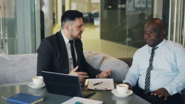 Onun Afro-Amerikan çalışan ve kapmak azar takım elbiseli kızgın bussinessman üzerinde onun kravat işaret modern Café sözleşmesindeki başarısız. Öfkeli patron masa eliyle endişeyle çarpıcı