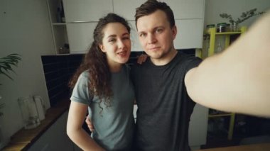 Genç Pov mutlu çift evde mutfakta video sohbet söz