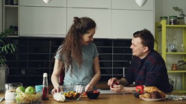O evde mutfakta yemek yaparken arkadaşına teklif yapma genç adam. O yüzüğü parmağına koyarak ve mutlu kız öpüşme