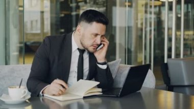 Laptopc omputer, smartphone üzerinde konuşmak ve öğle yemeği molası sırasında kafe iş bilgileri yazma sakallı Kafkas işadamı
