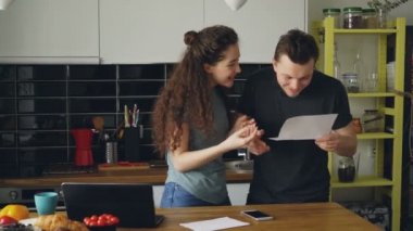 Çekici mutlu çift mutfakta iyi haber unfolding mektup almak süre evde kahvaltı var