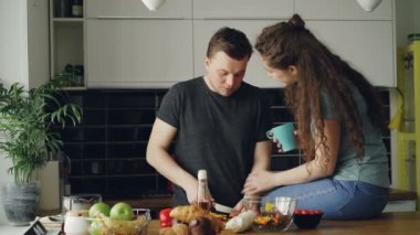 Mutlu mutlu genç çift yemek ve sohbet adam kesme sebze evde mutfakta kahvaltı için tamamlayın. İlişki ve aile kavramı