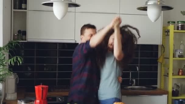 Casal jovem louco no amor dançando juntos dança rocknroll na cozinha em casa em férias — Vídeo de Stock