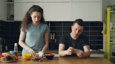 Çekici çift mutfakta. Adam akıllı kız arkadaşı yemek sırasında video oyun oynarken