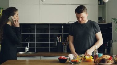 sebze salatası için mutfak kesme biber masada duran ev gibi yakışıklı genç beyaz kocası öpüşme telefonda konuşurken genç güzel iş kadını