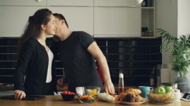 genç güzel beyaz çok kıvırcık işkadını iş, yakışıklı kocası eve geldiğinde yemek, sarı biber kesme, onlar öpüşme ve gülüyor