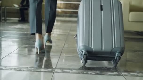 Dolly strzał nogi kobieta spacerując po holu ciągnięcie bagażu i zatrzymują się na recepcji. Koncepcji biznesowych, Podróże i ludzi — Wideo stockowe