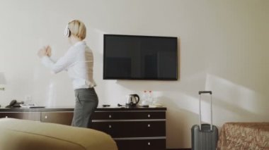 Dans ve müzik dinleme sırasında şarkı mutlu işkadını kablosuz kulaklıklar iyi eğlenceler otel odamda yürüme. Seyahat, iş ve insan kavramı