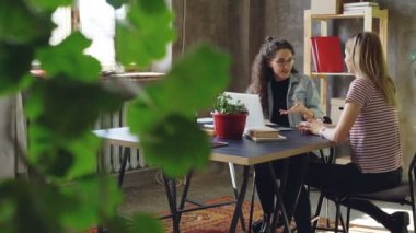 Genç iş ortakları, modern ofis masasında otururken Projesi'nde birlikte çalışıyoruz. Onlar konuşurken, mimik ve notlar. Yaratıcı takım kavramı.