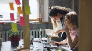 Modern ofis tasarım proje üzerinde çalışırken onun meslektaşım fikir paylaşımı çok kadın girişimci. O ona bilgi sayfasında, söz ve ekran birlikte izlerken gösteriyor.