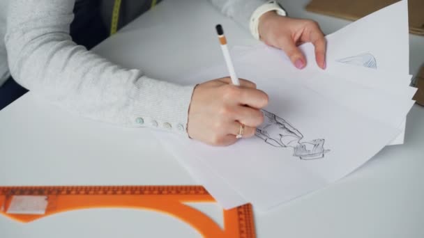 Szczegół tilt strzał kobieta ręce szkicu rysunku ubrania damskie z ołówkiem, a następnie Wyświetlono atrakcyjna twarz projektanta koncentruje się na szkicowanie. — Wideo stockowe