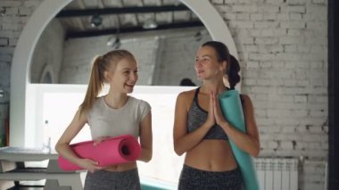 Yoga eğitmeni genç sarışın öğrenci ile birlikte çalışmadan sonra studio yürürken sohbet. Öğretmen-öğrenci kayıt dışı iletişim kavramı.