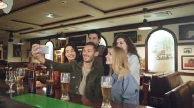 Arkadaş grubu güzel barda selfie smartphone üzerinden alıyor. Güzel rahat kıyafetler poz ve sahip eğlenceli insanlar. Dinlendirici atmosfere mutluluk kavramı.