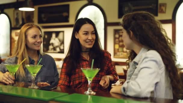 Die besten Freunde prosten sich zu, klimpern Gläser und trinken Cocktails in einer schicken Bar. Frauen feiern gemeinsam etwas. — Stockvideo