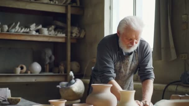 Potier expérimenté pétrit de l'argile avec ses mains sur la table de travail dans l'atelier. Création eathenware, ustensiles faits à la main et concept de poterie professionnelle . — Video