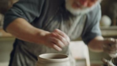 Deneyimli sakallı Fransız profesyonel araçlar kullanarak tekerlek atma gelen toprak kap kesiyor. Geleneksel eathenware ve geleneksel seramik konsept oluşturma.