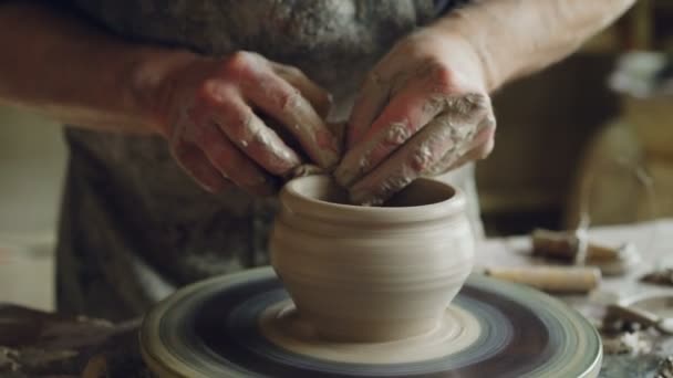 专业的波特正在制作 clayware 在波特的车轮上, 看着半成品壶和检查质量的工作。传统职业与创造陶瓷理念. — 图库视频影像
