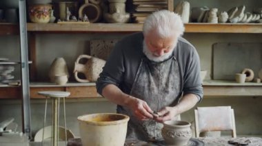 Deneyimli usta kulak seramik kase için yapım ve rahat işyerinde çalışırken clayware üzerinde sabitleme. Çanak çömlek, meslek ve hobi kavramı.