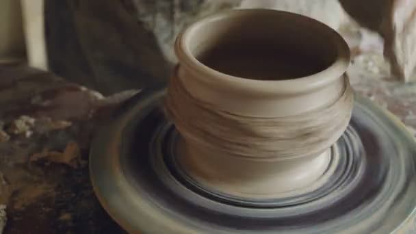 Close-up shot of male hands working with clay on spinning potters throwing wheel, decorating pot, making ornament. Pottery, hobby and handicraft concept. — Stock Video