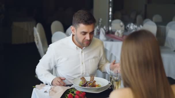 Jeune homme barbu se dispute avec sa petite amie tout en dînant au restaurant puis en partant. querelles amoureuses, émotions négatives et concept de crise relationnelle . — Video