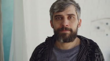 Yakın çekim portre yakışıklı adam kahverengi gözlü ve rahat kıyafetler giymiş ve kameraya bakarak grimsi saç sakallı. İnsanlar ve iç kavramı.
