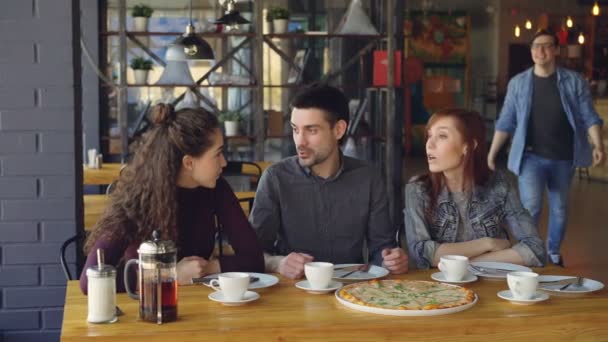 カジュアルなデニムの服でハンサムな若い男は、カフェ遅刻、挨拶のハイタッチと彼の仲間の彼の友人を満たしています。友情と概念外食. — ストック動画