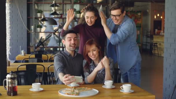 Glada ungdomar populära bloggare tar selfie poserar skratta och ha roligt i café. Modern teknik, sociala medier, vänskap och fritid koncept. — Stockvideo