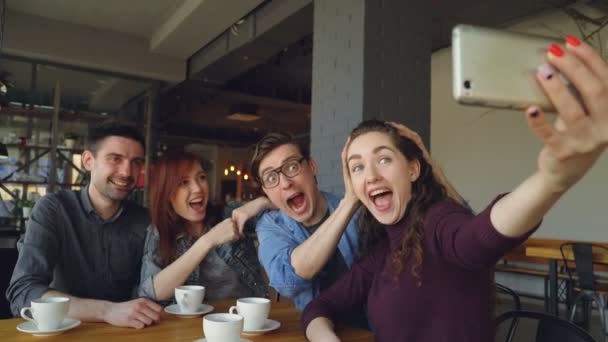 Amigos felices están tomando selfie en la pizzería, haciendo caras y gestos divertidos y riendo y luego viendo fotos. Millennials, conexión y concepto de estilo de vida moderno . — Vídeos de Stock