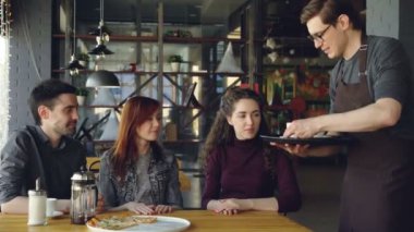 Dost garson önlük içecekler bardak kafede masada oturan sosyalleşme gençlere hizmet vermektedir. Yiyecek ve İçecek sanayi, dışarıda yemek, Toplantı arkadaş ve dostluk kavramı.