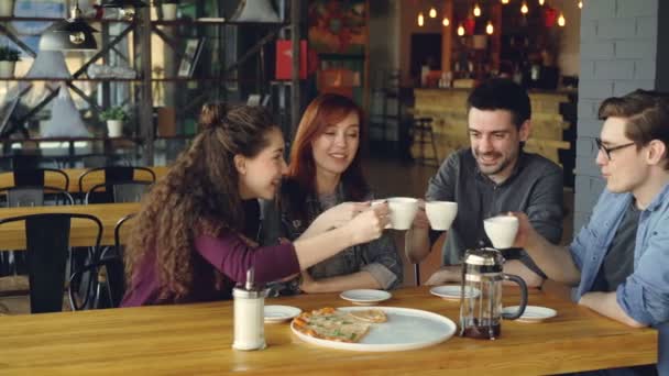 Přátelé slaví setkání v kavárně nad nápoje a pizzu, řinčení poháry, pití a sdílení zpráv. Přátelství, moderní životní styl, koncept komunikace a oslava. — Stock video